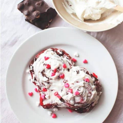 Red Velvet Cinnamon Rolls on plate with sprinkles