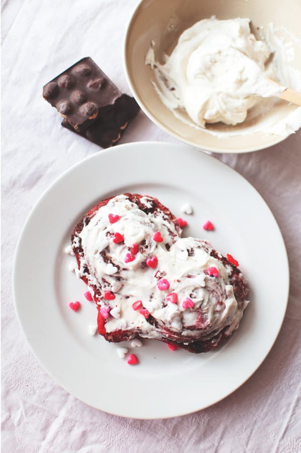 Red Velvet Cinnamon Rolls on plate with sprinkles