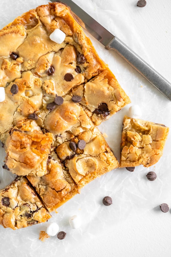 S'mores Blondies on white parchment paper with knife.