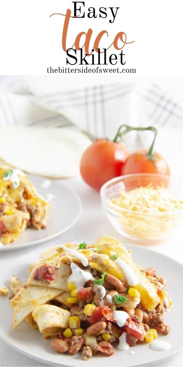 taco skillet on plate with cheese and tomatoes in background.