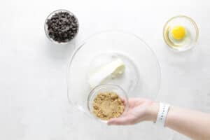 adding brown sugar to glass bowl.