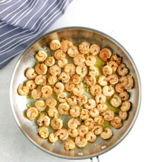 uncooked shrimp in glass bowl cooked in pan.