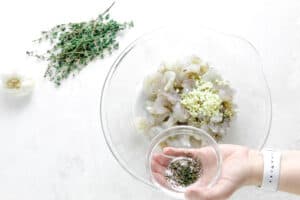 uncooked shrimp in glass bowl. with thyme.