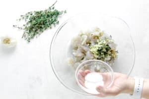 uncooked shrimp in glass bowl with salt.