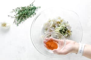 uncooked shrimp in glass bowl with cayenne pepper.