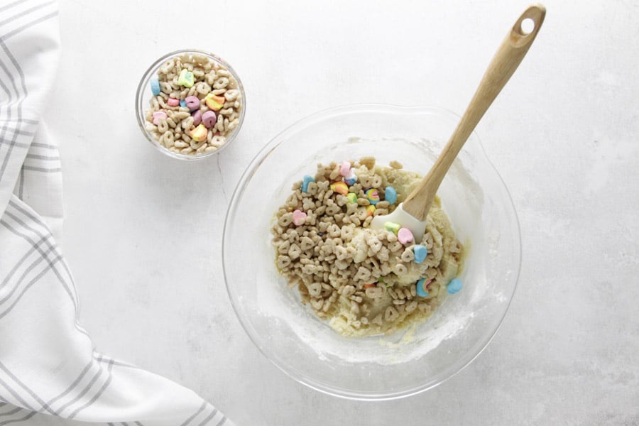 cereal adding to mix in glass bowl.