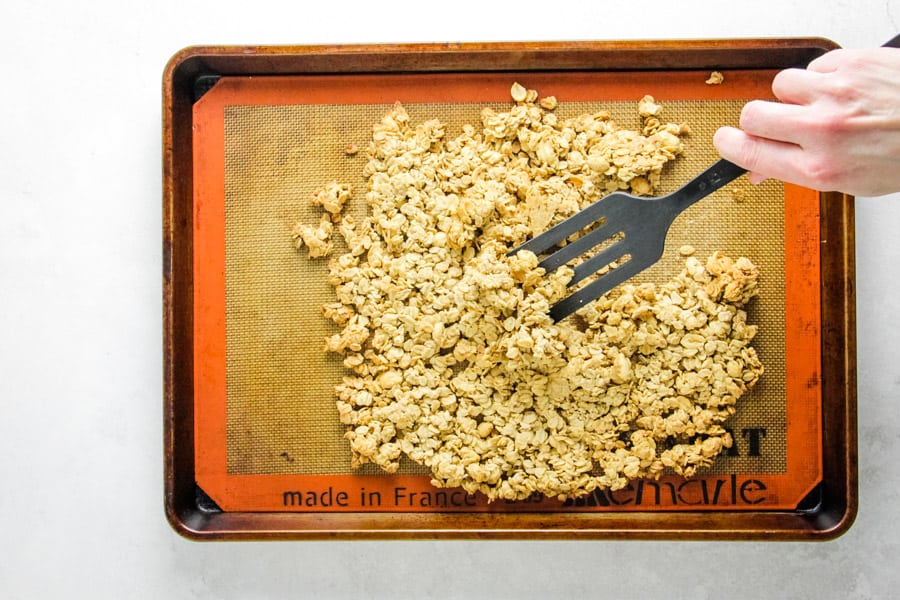 breaking up granola on sheet pan.