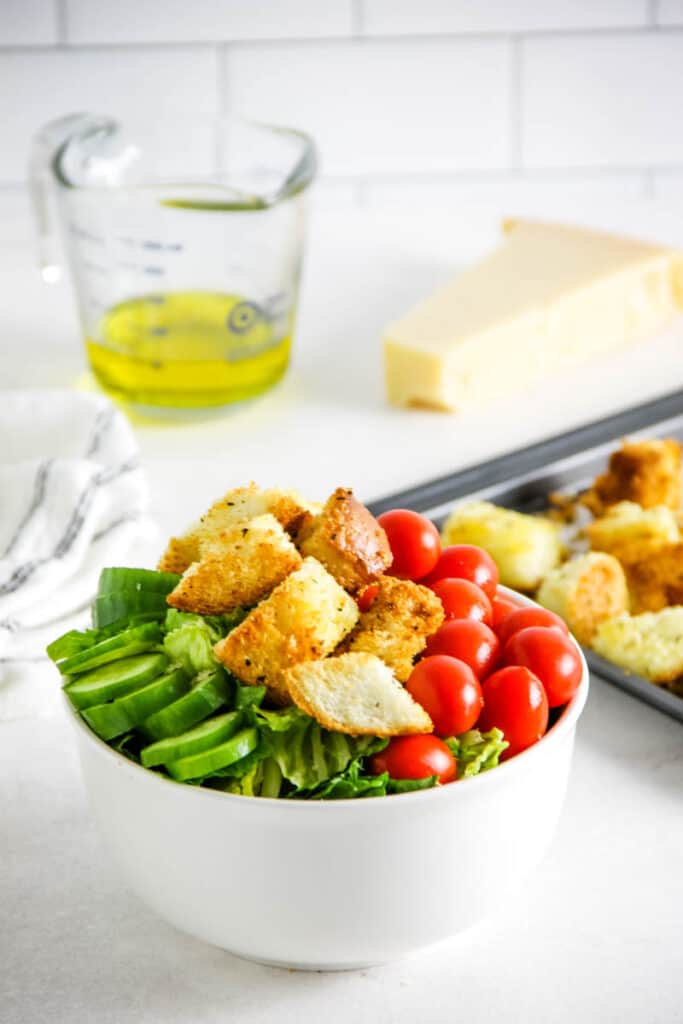 croutons topped on salad in white bowl.