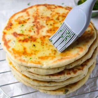 brushing flatbread with oil and herbs.