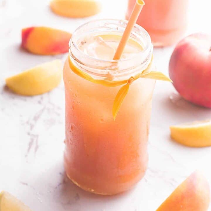 Peach Black Tea Lemonade in glass jar with straw.