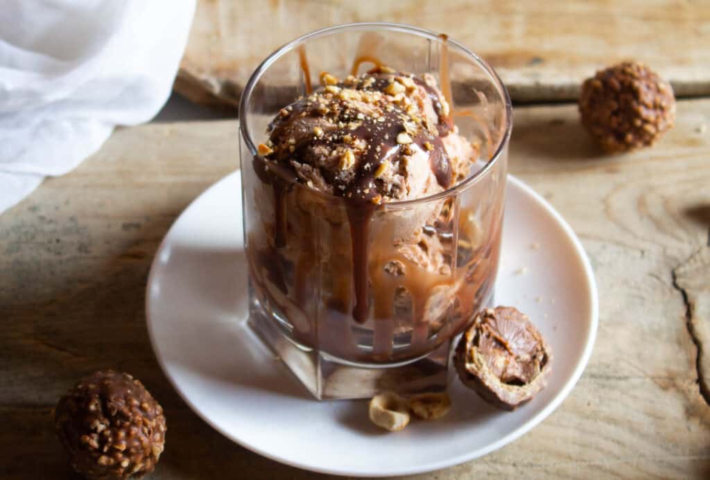 Ferrero Rocher Ice Cream in glass cup on white plate.