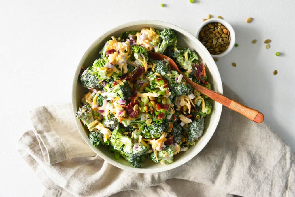 Easy Broccoli Salad in white bowl with spoon.