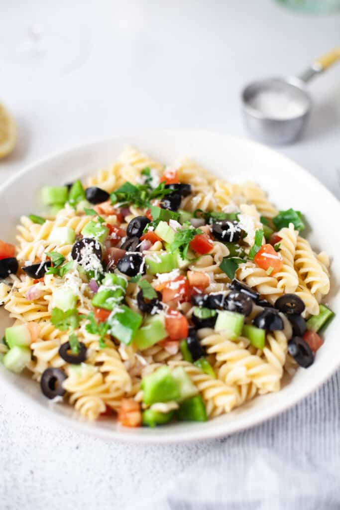 Greek Pasta Salad topped with cheese and cilantro.