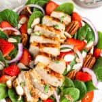 Strawberry Chicken Spinach Salad in bowl topped with pecans.