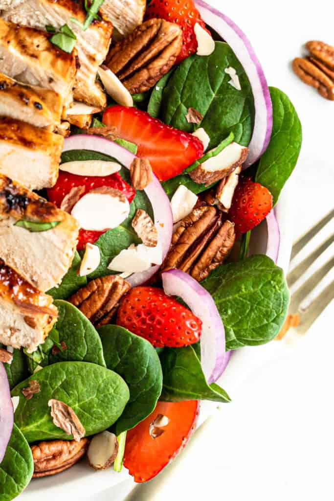 Strawberry Chicken Spinach Salad topped with strawberries.