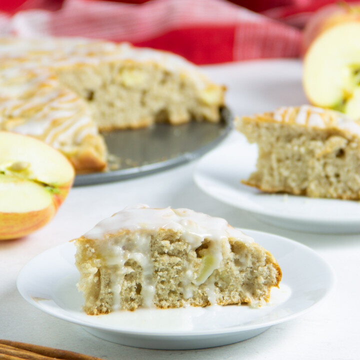 Apple Cake on plate with icing drizzled on top.