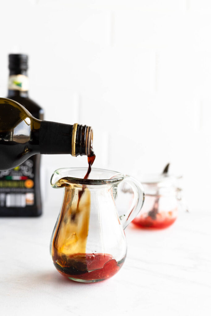 adding balsamic to glass pitcher.