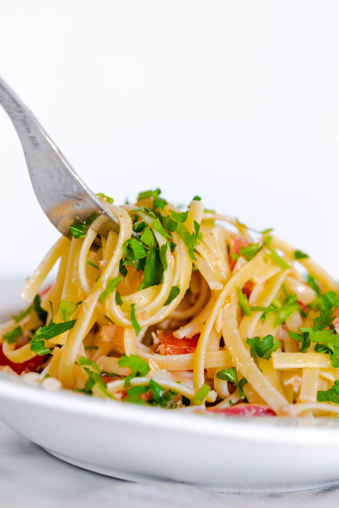 Tuna Pasta with Tomato in white bowl with fork.