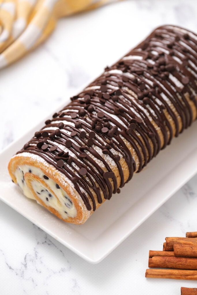 overhead view of Chocolate Chip Pumpkin Roll on white plate.