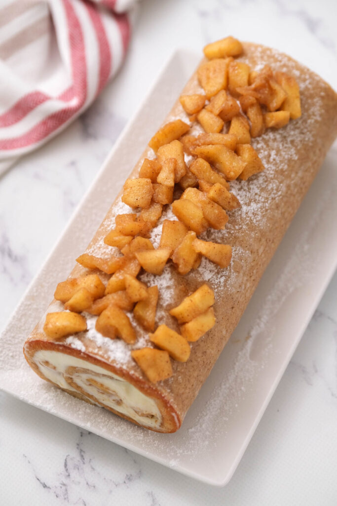 overhead view cinnamon apple cake roll on plate.