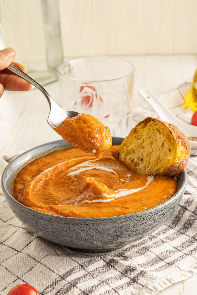This Homemade Tomato Soup cooks up in just about 30 minutes! Creamy, rich, and filled with fresh tomatoes and basil! a spoonful of homemade tomato soup.