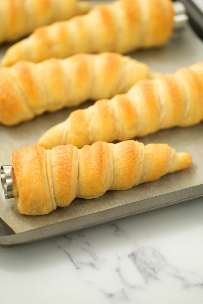 cooked cream horns on sheet pan.