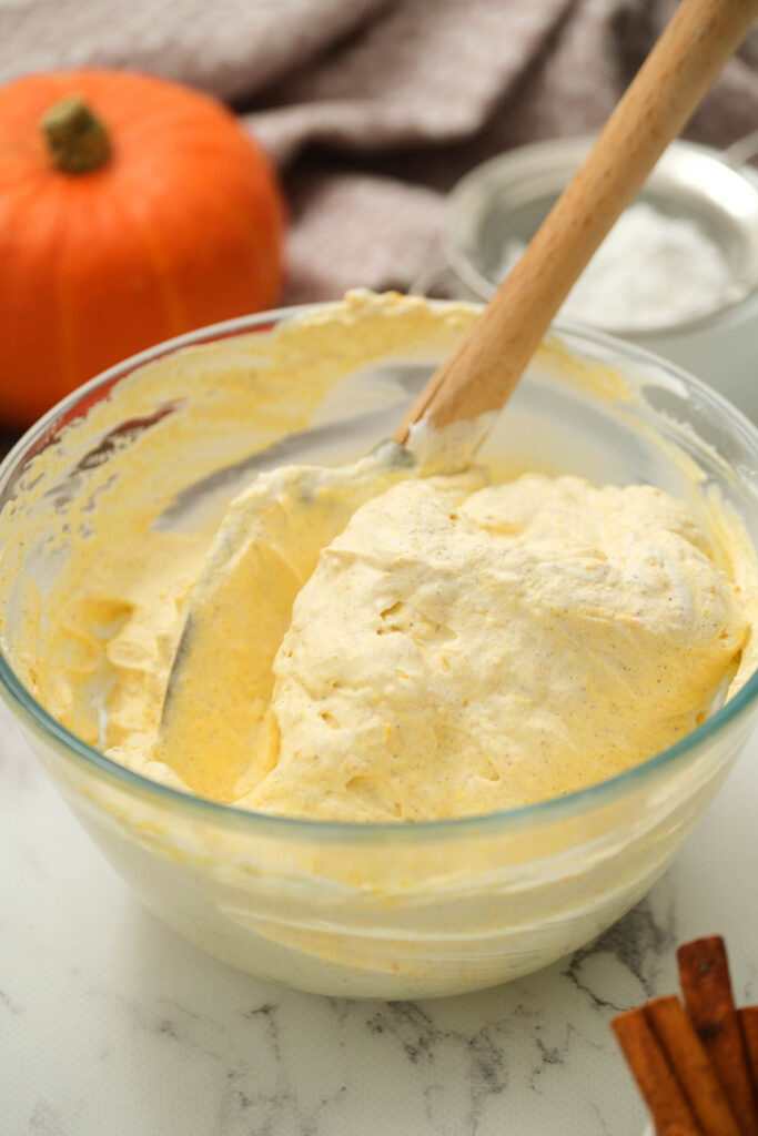 whipped cream mixed with pumpkin in bowl.