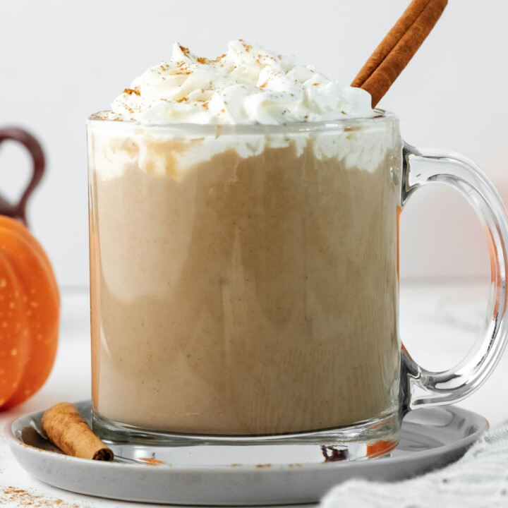 latte in glass cup topped with cream.