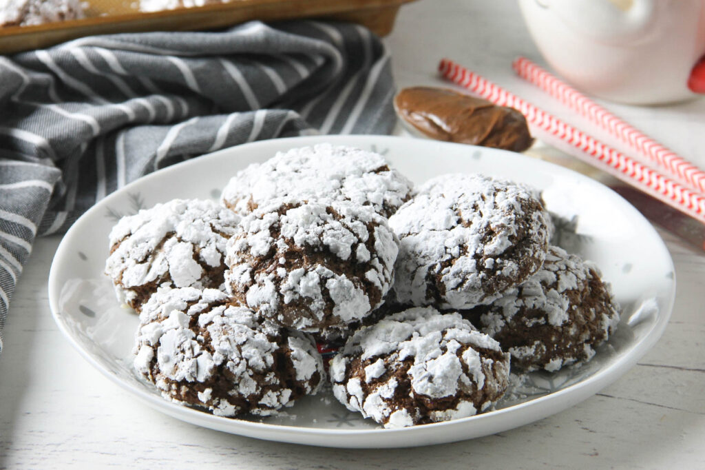 Chocolate Hazelnut Crinkle Cookies stacked on plate.