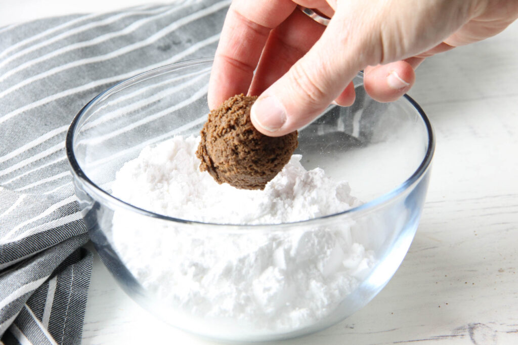 placing dough into powdered sugar.