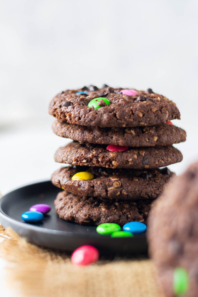Double Chocolate Monster Cookies stacked on top of each other.