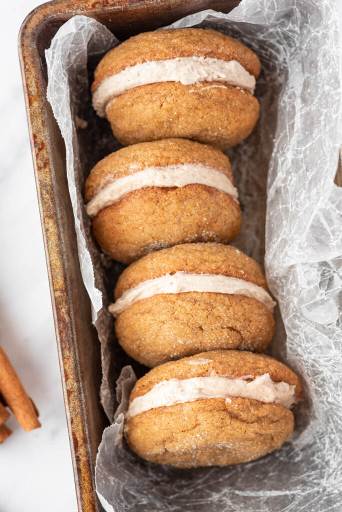 Ginger Molasses Cookie Sandwiches displayed in loaf pan with parchment paper.