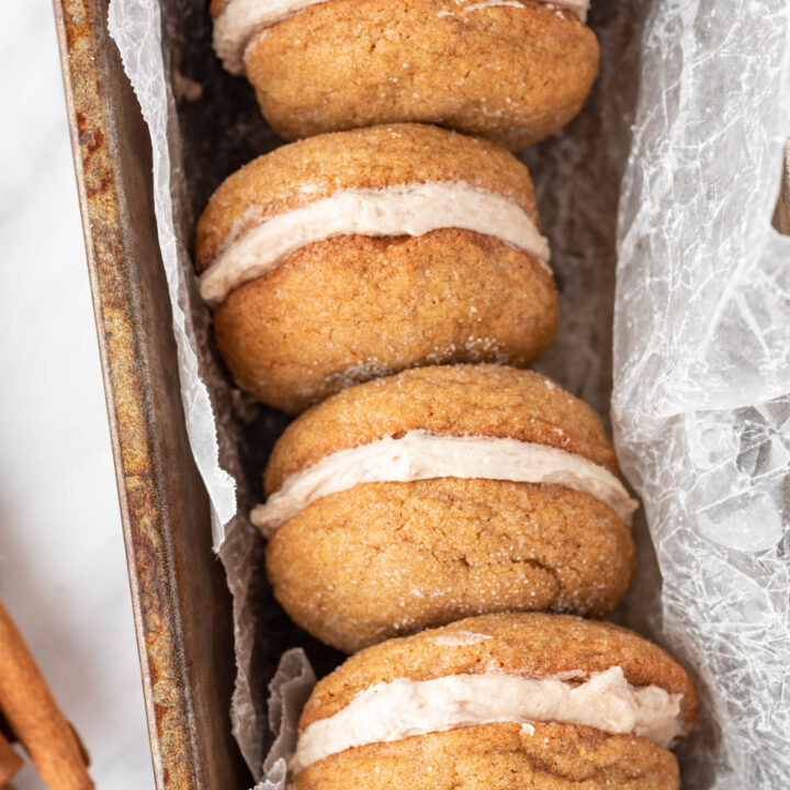 Ginger Molasses Cookie Sandwiches displayed in loaf pan with parchment paper.