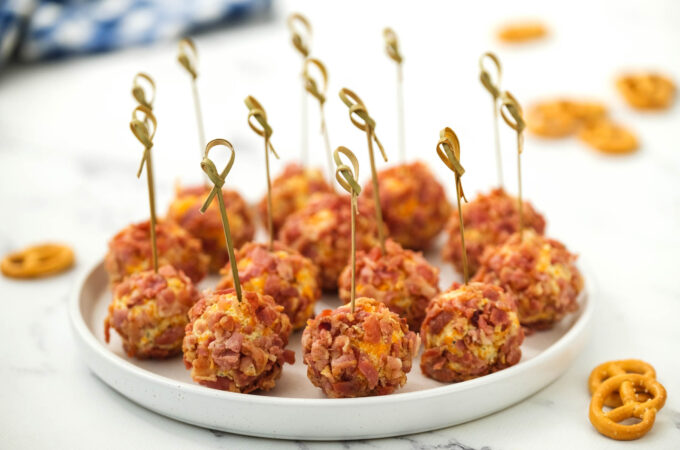 Mini Bacon Ranch Cheeseballs on white plate with toothpick.