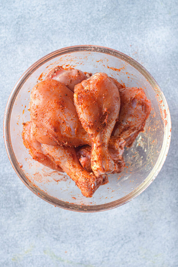 drumsticks in bowl with seasonings.