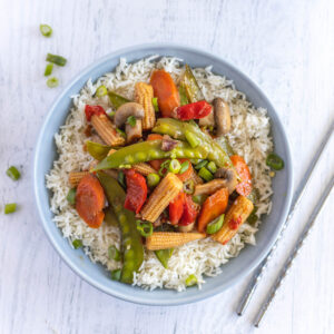 stir fry on rice in blue bowl.