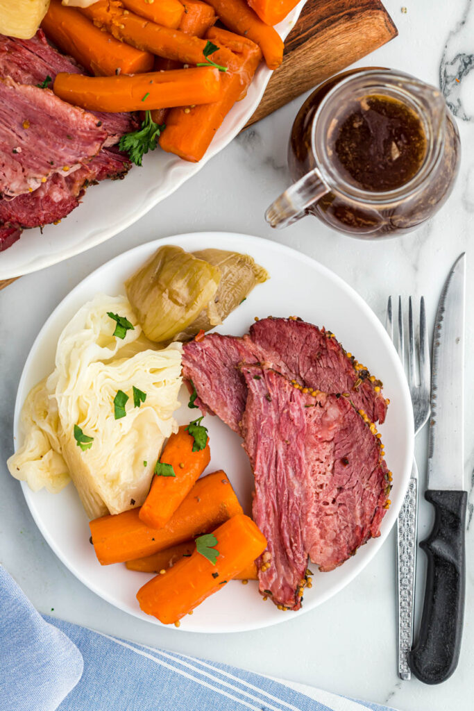 overheard view of corned beef and veggies on white plate.