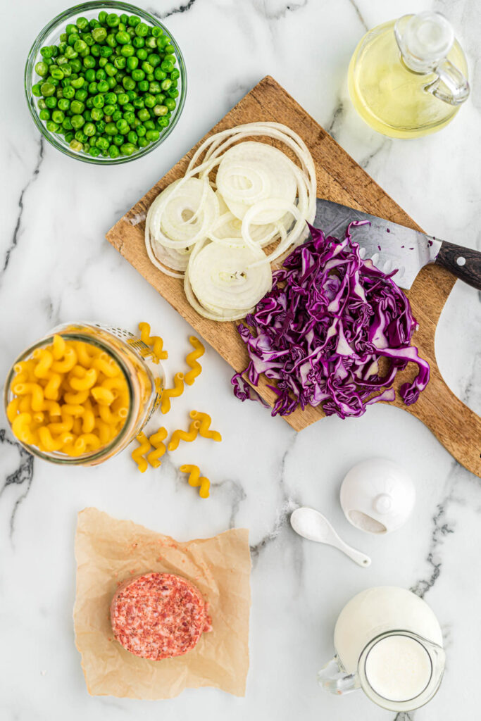 ingredients for sausage pasta on white background.