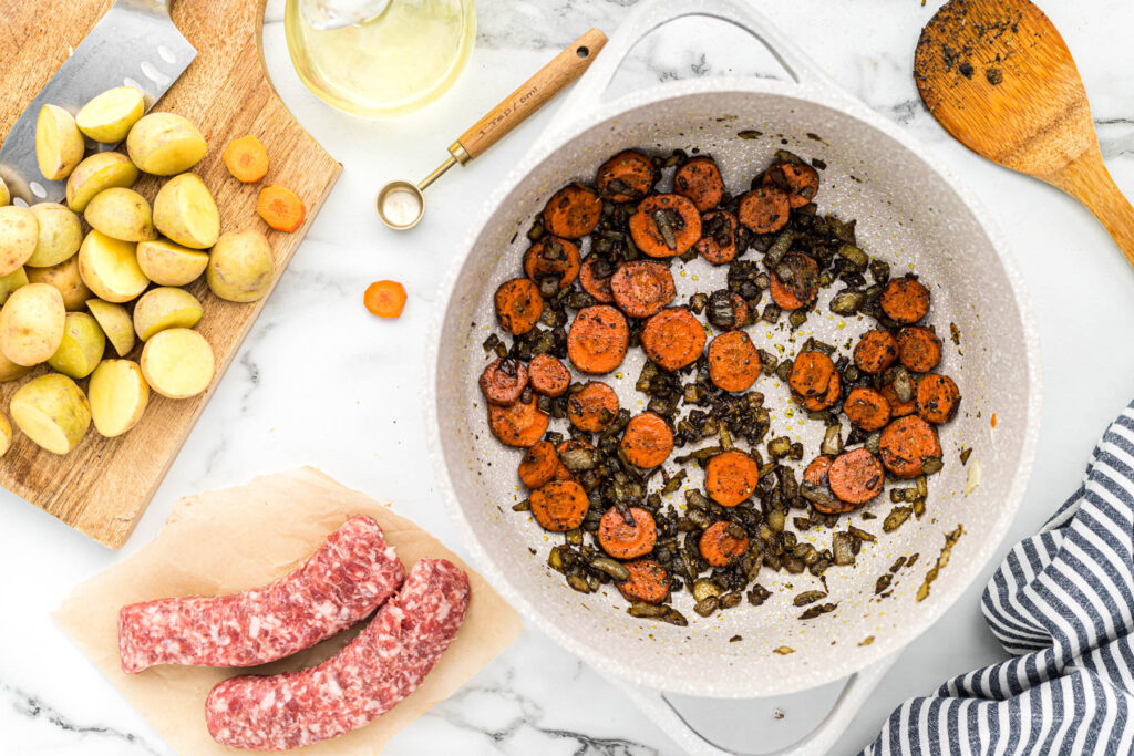 onions and carrots cooked in pot.