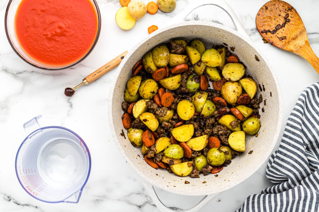 sausage, carrots, and potatoes cooked in pot.