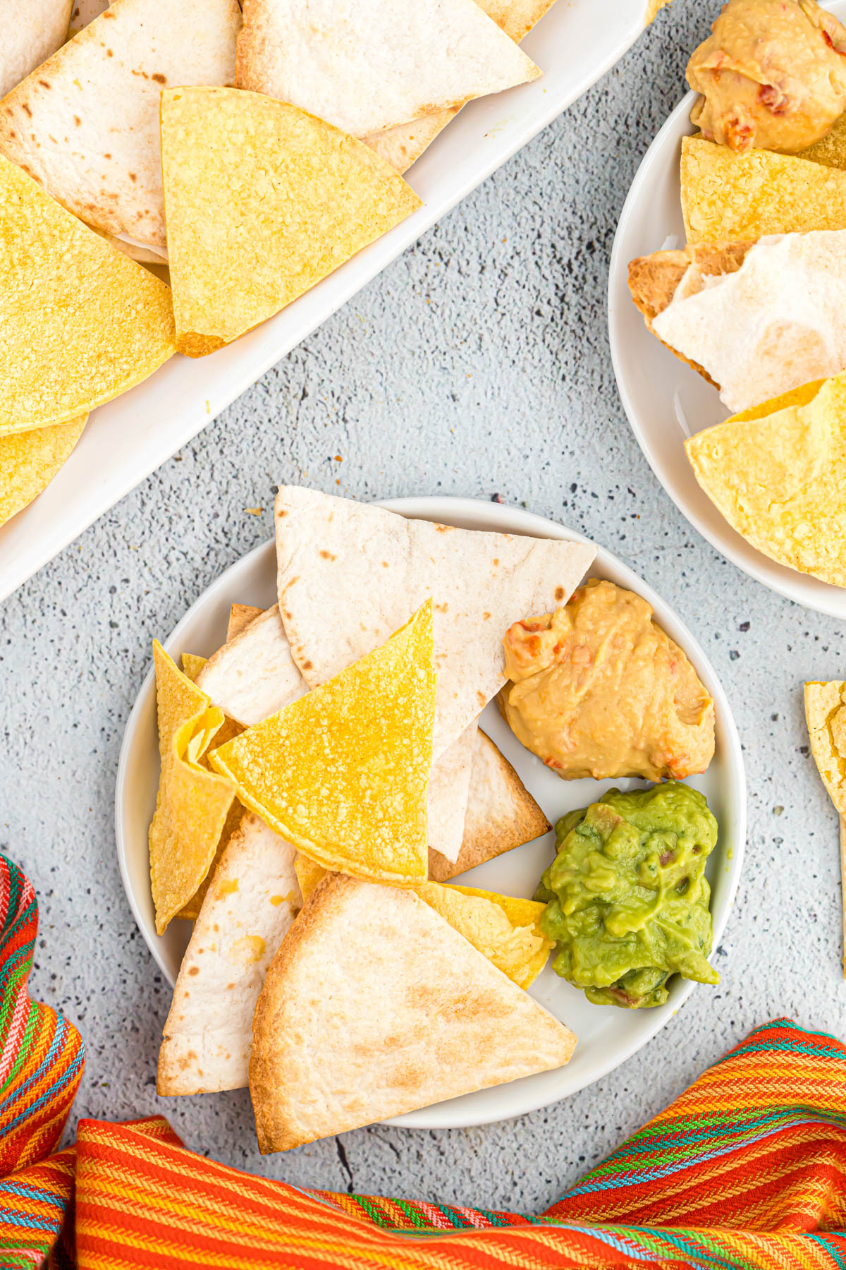 chips on plate with guacamole and hummus.