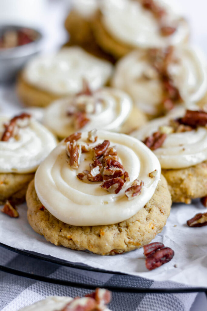 close up of cookie with frosting and pecans.