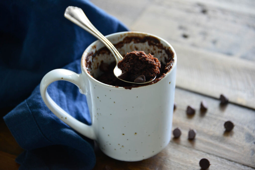 spoon on top of white mug cake.