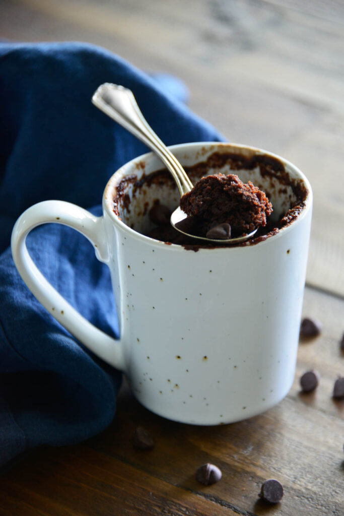 Easy Chocolate Mug Cake made in the microwave in under 2 minutes! Warm chocolate cake with easy ingredients and cooked to perfection! Chocolate Mug Cake in white mug.