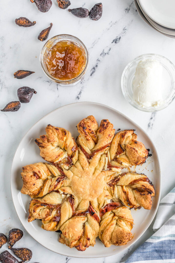 Prosciutto, Fig and Goat Cheese Star Bread on plate on white background.