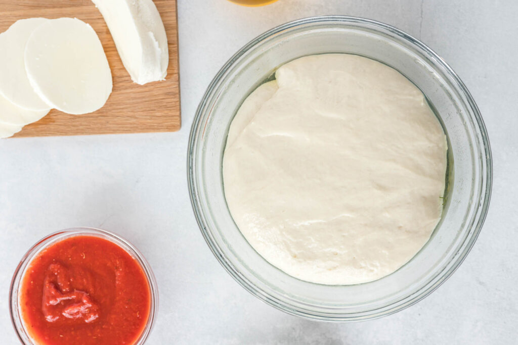 dough rising in glass bowl.