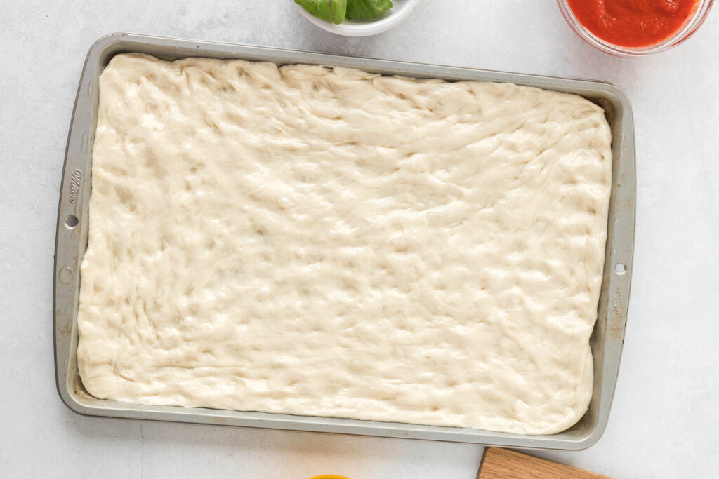 dough spread out in sheet pan.