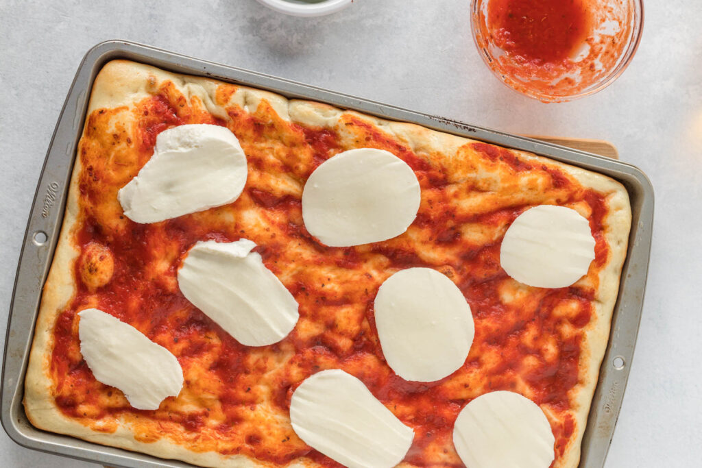 fresh mozzarella topped on pizza dough.