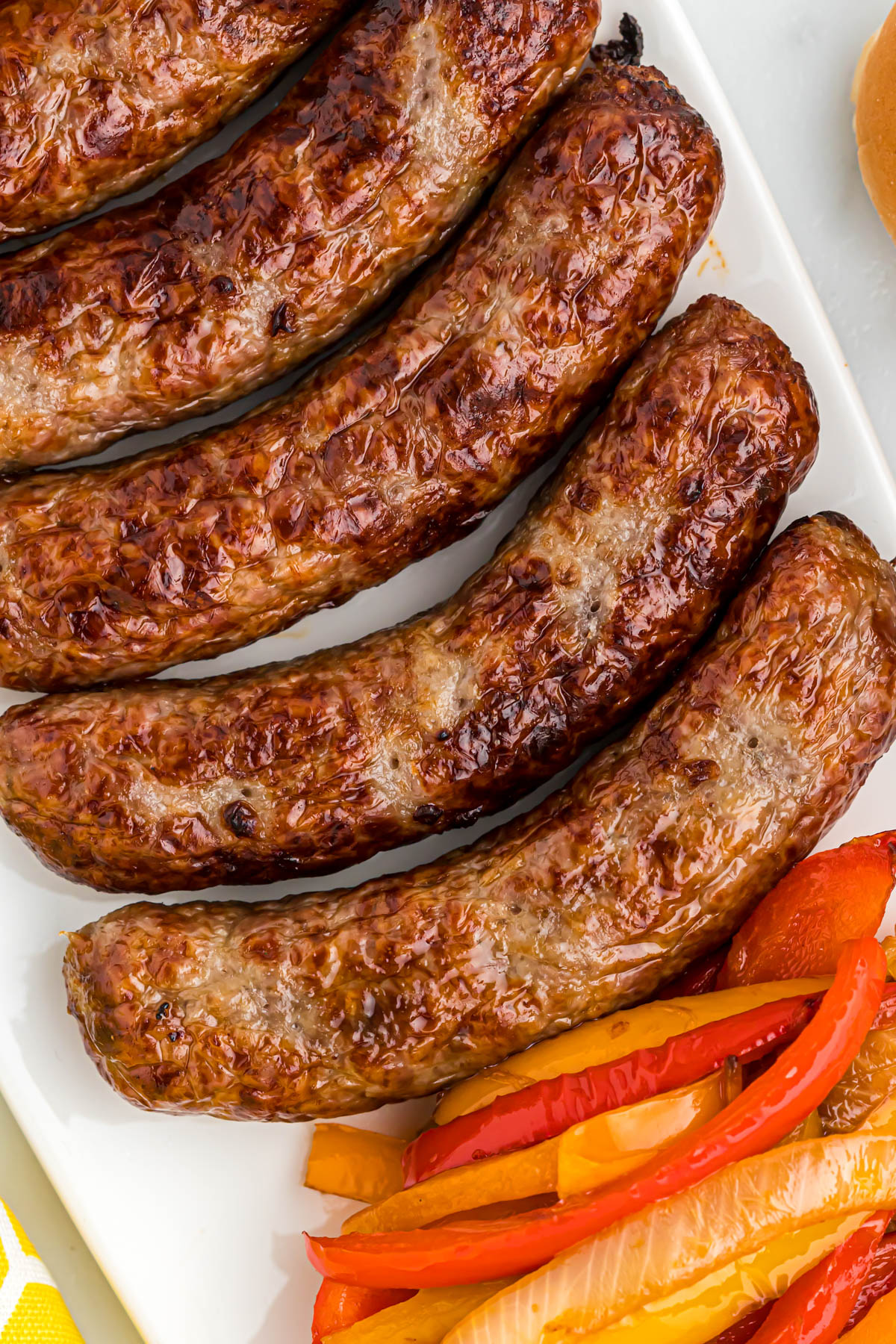 cooked bratwurst on white tray.