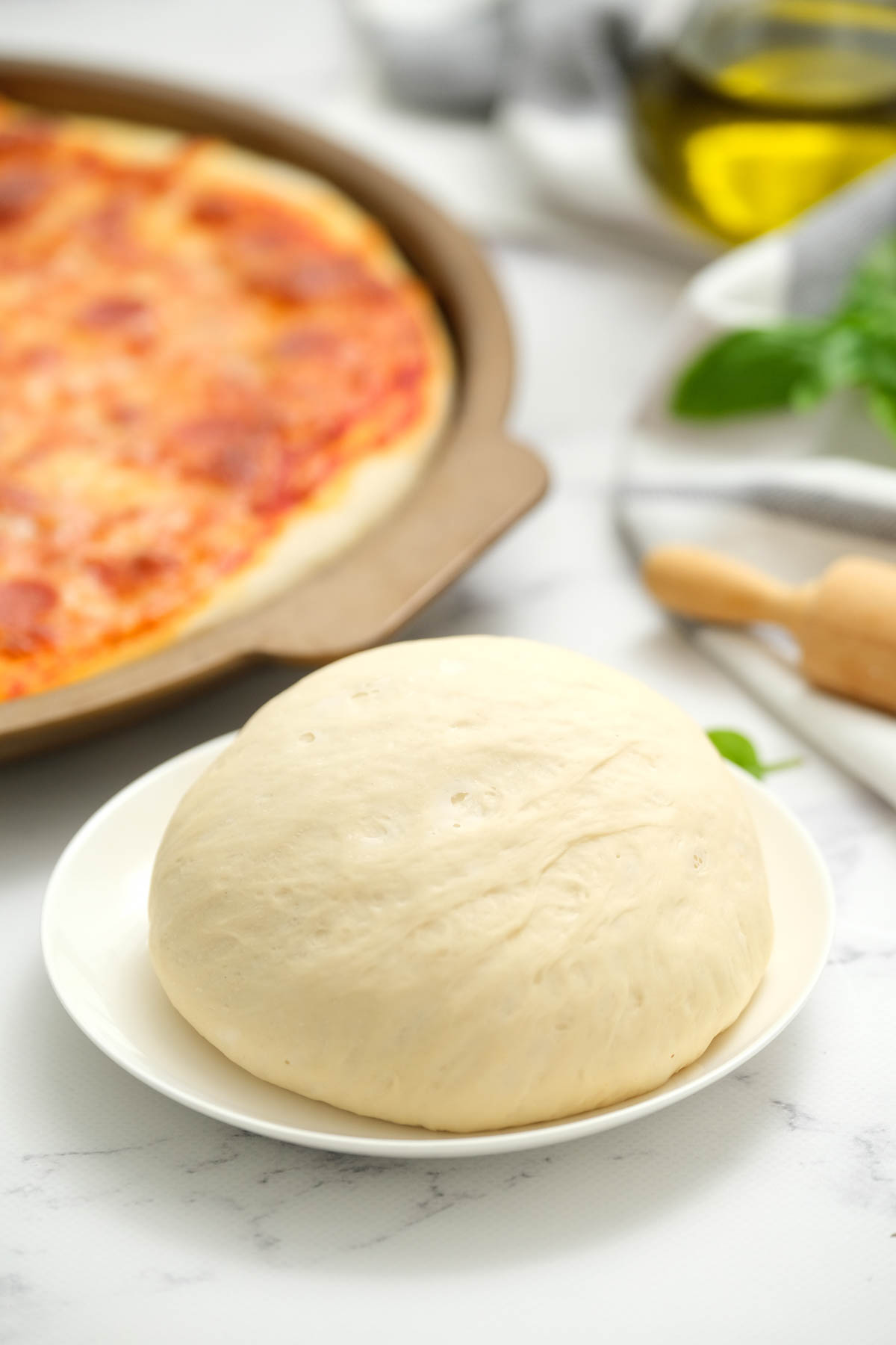 uncooked Pizza Dough on white plate.